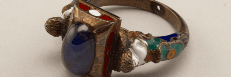 Timeless jewelry antique gold ring with cabochon sapphire, cloisonne enamel, and pearl accents.