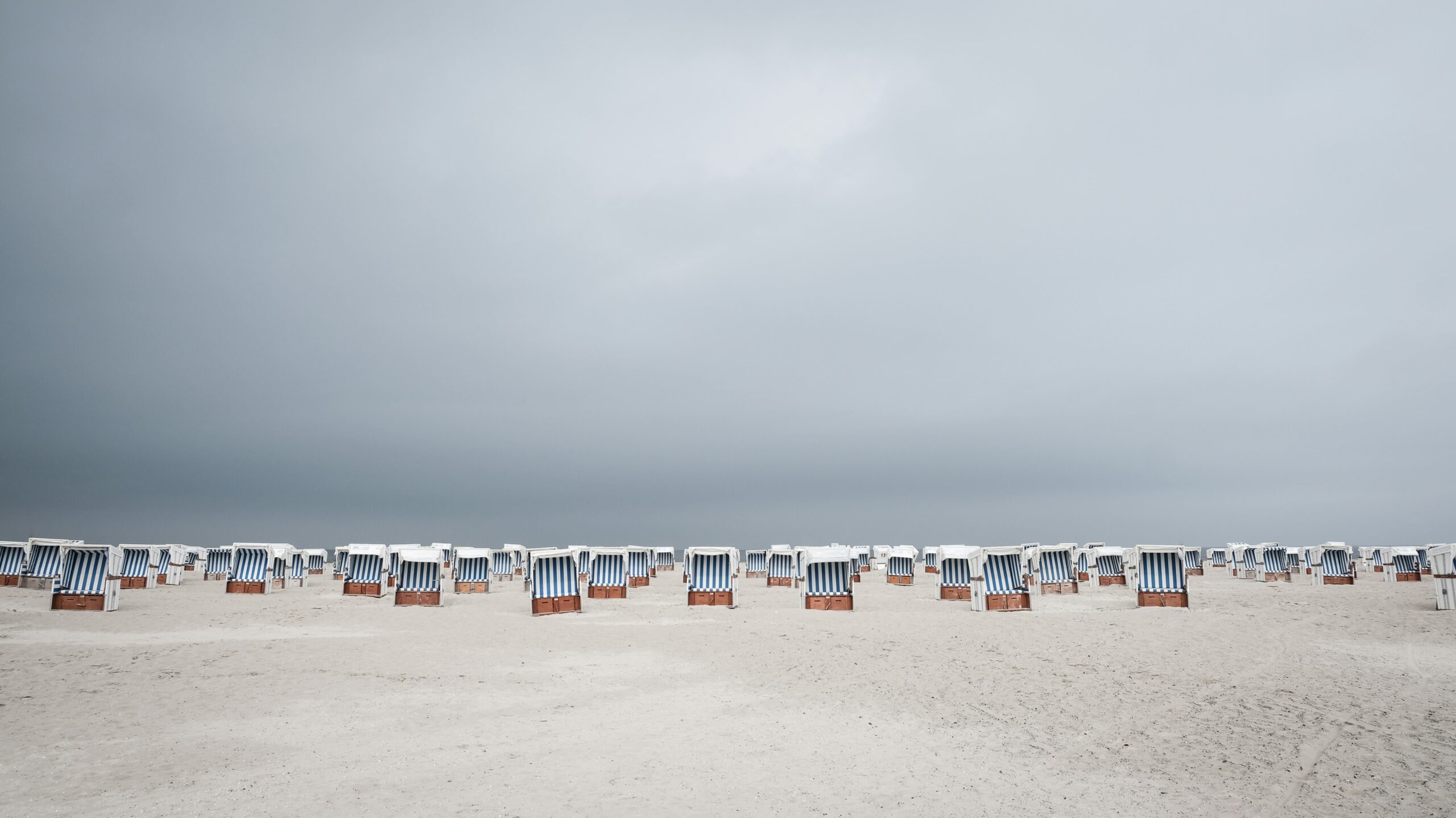 Strandkorb wicker chairs with blue striped canopy on German Baltic beach