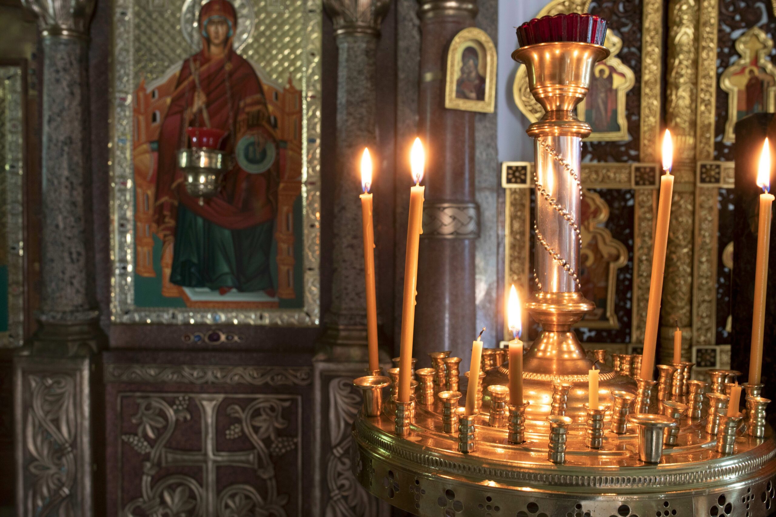 Gilded candelabra with beeswax candles before Orthodox icons — the Easter vigil tradition at its heart